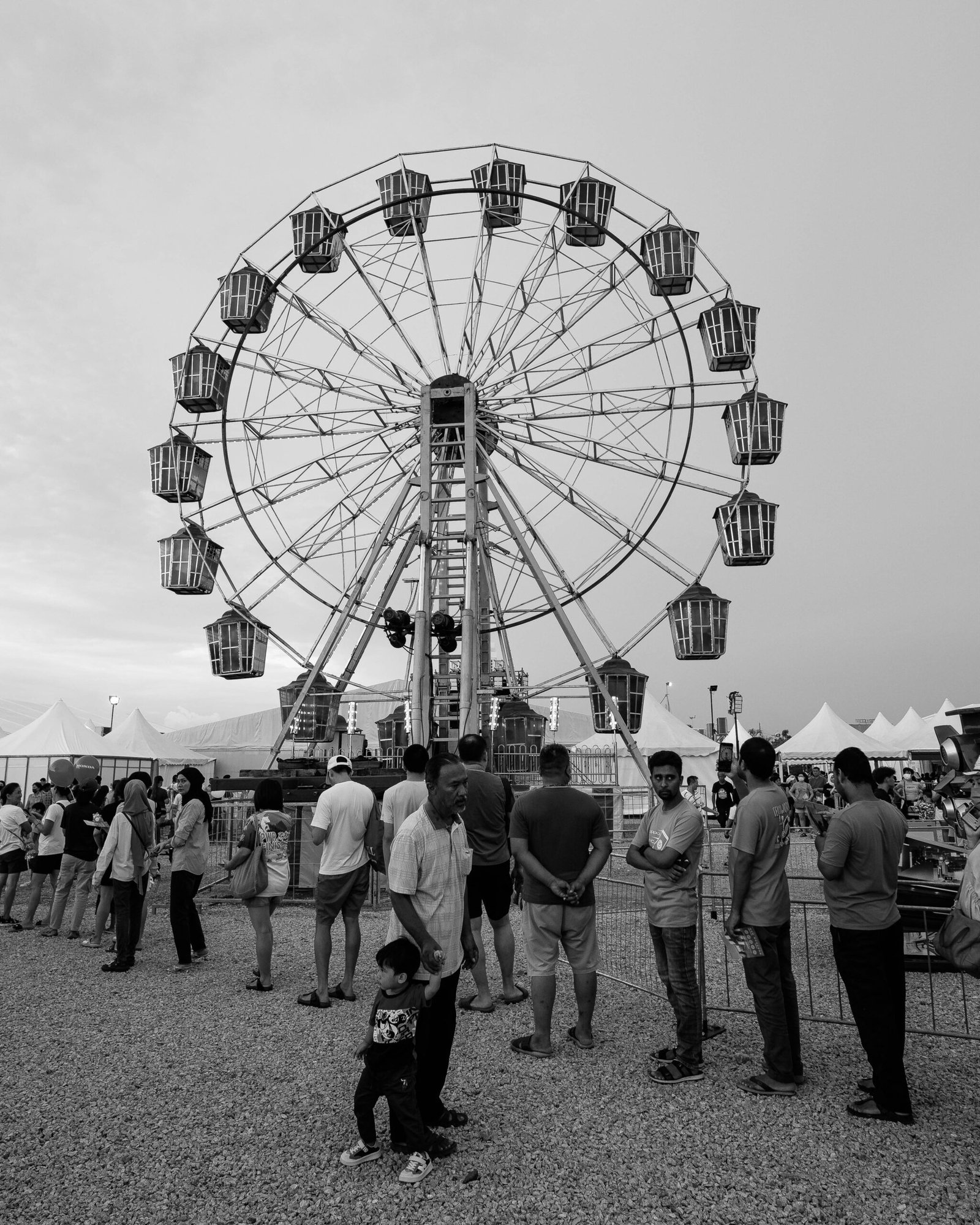a group of people standing around a ferris wheel